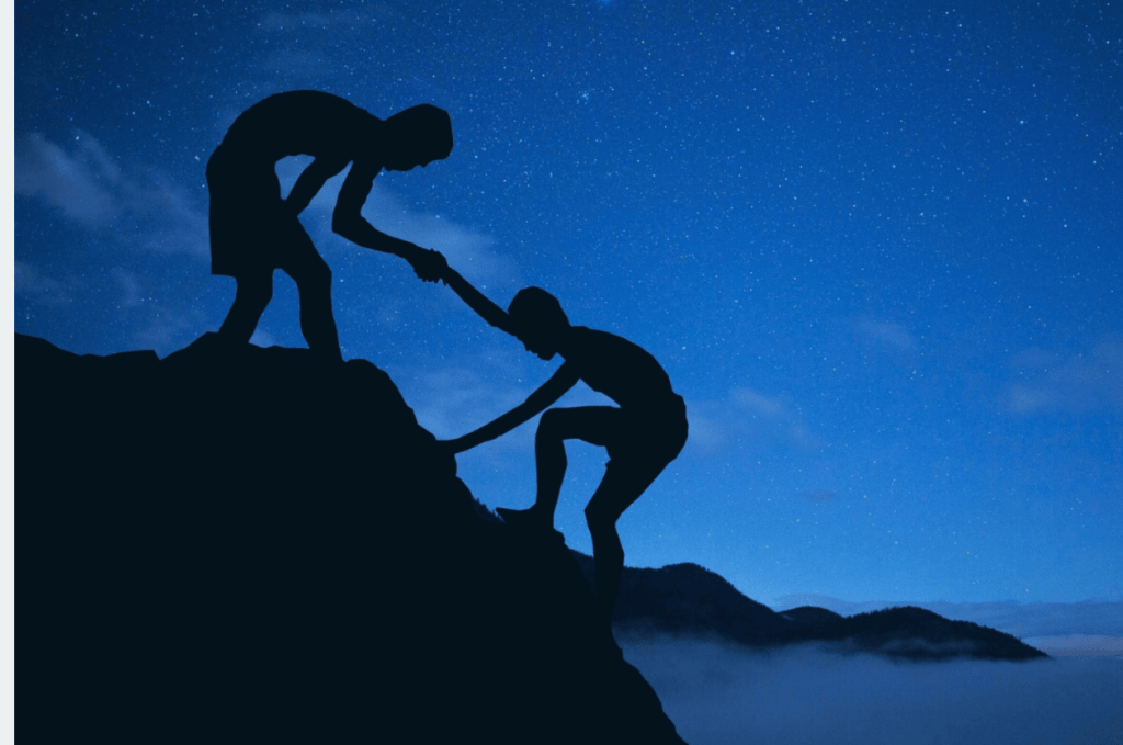 Image showing a person lifting another up a small hill in the dark